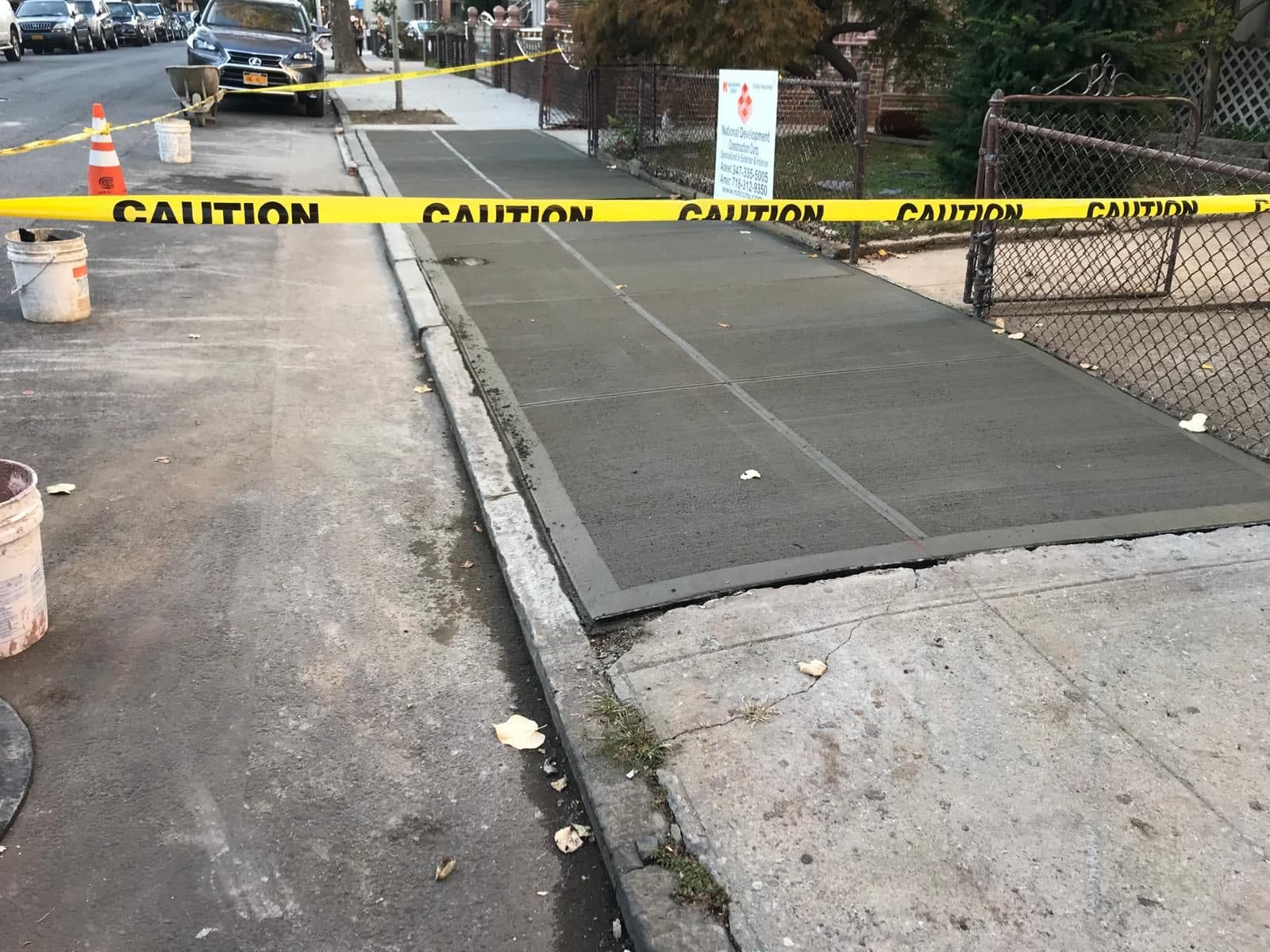 New concrete sidewalk poured along the fence