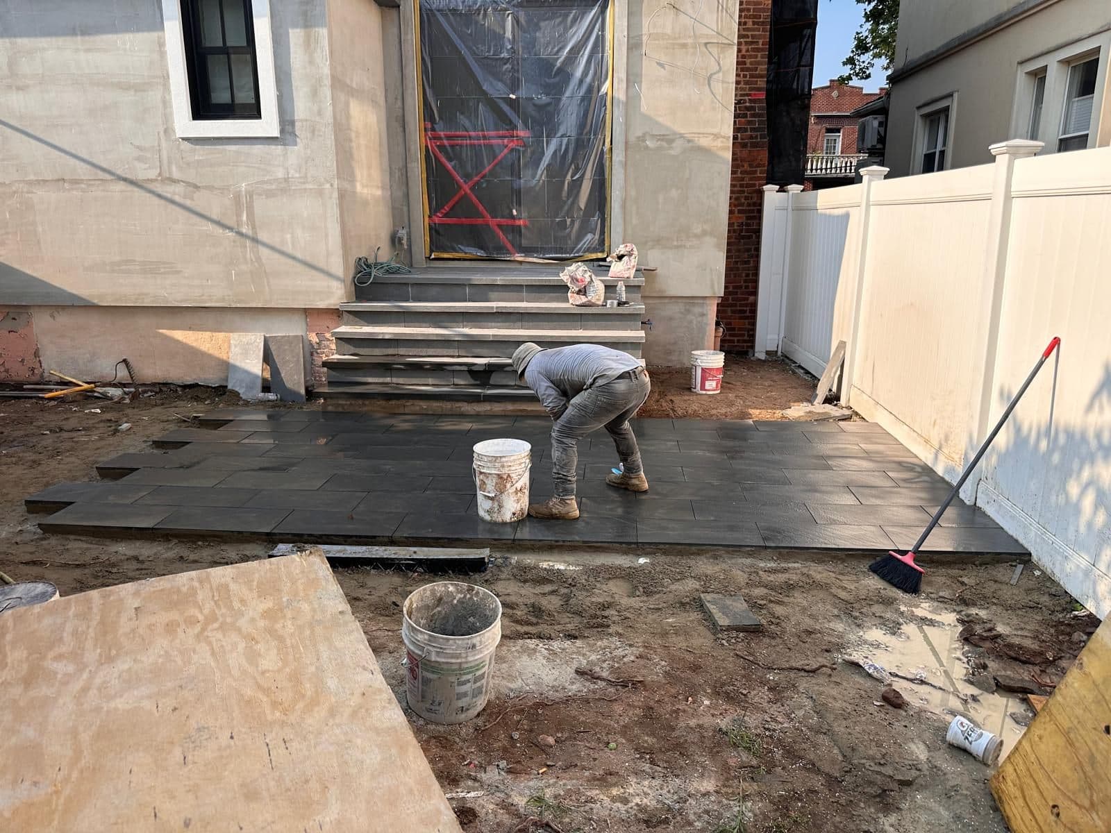 Crew preparing the backyard base for stone tiles