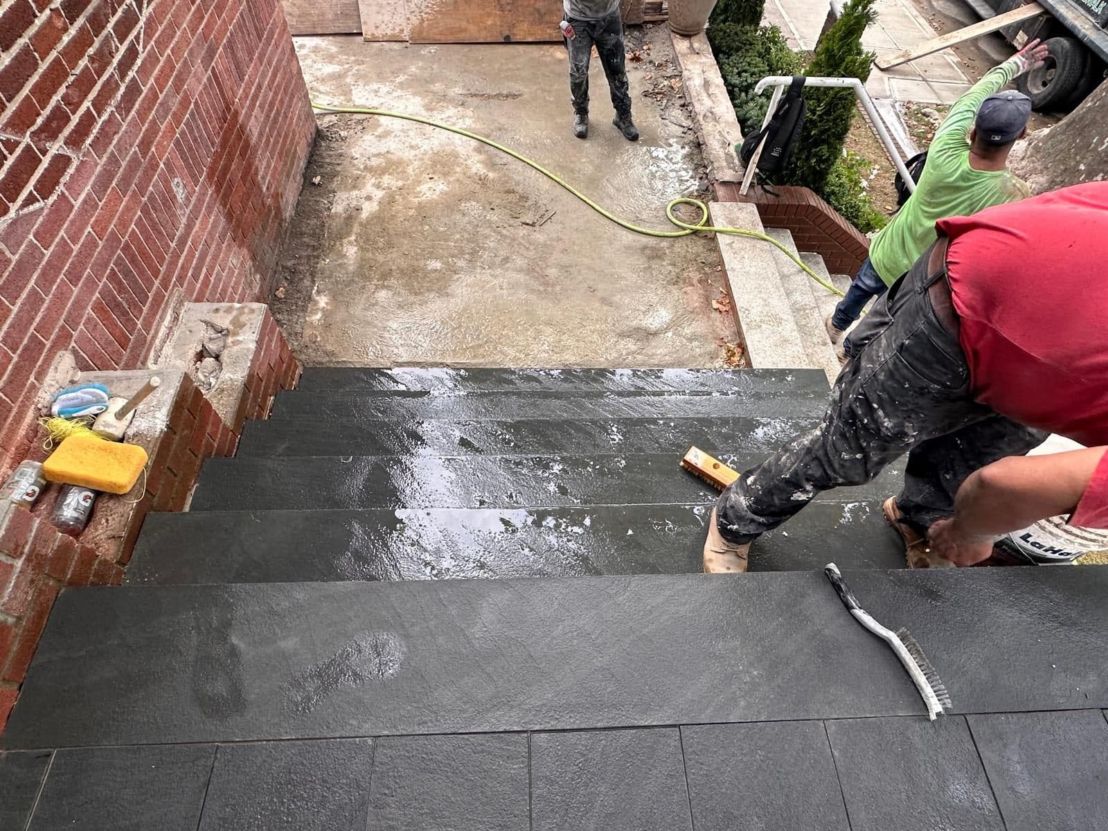 Mason cutting blue stone tiles to fit