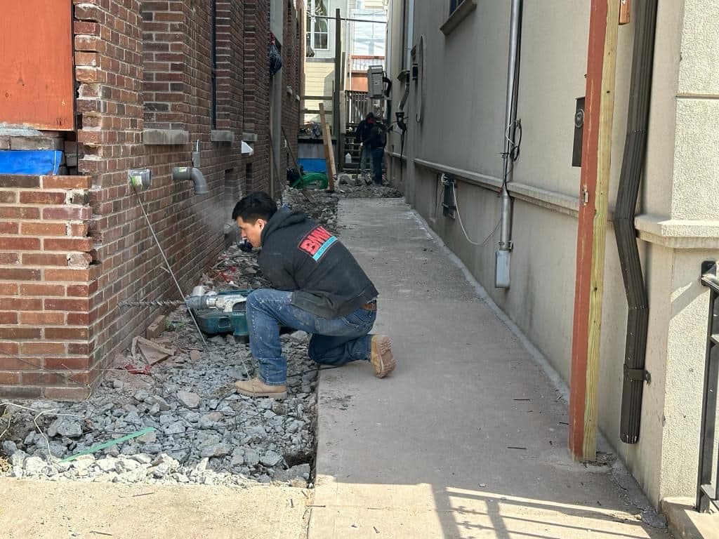 Mason working along the side of the house
