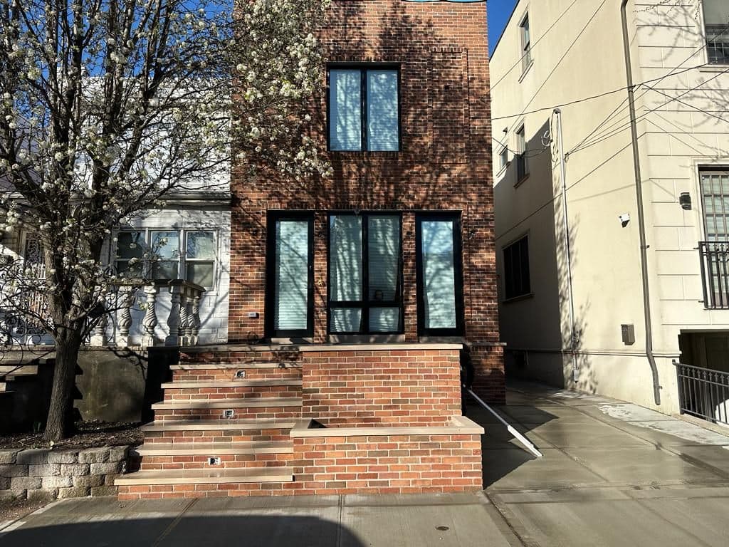 After: the same house front finished in brick with new steps