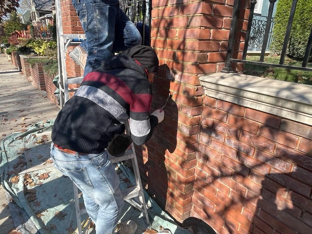 Mason grinding and pointing a brick pillar