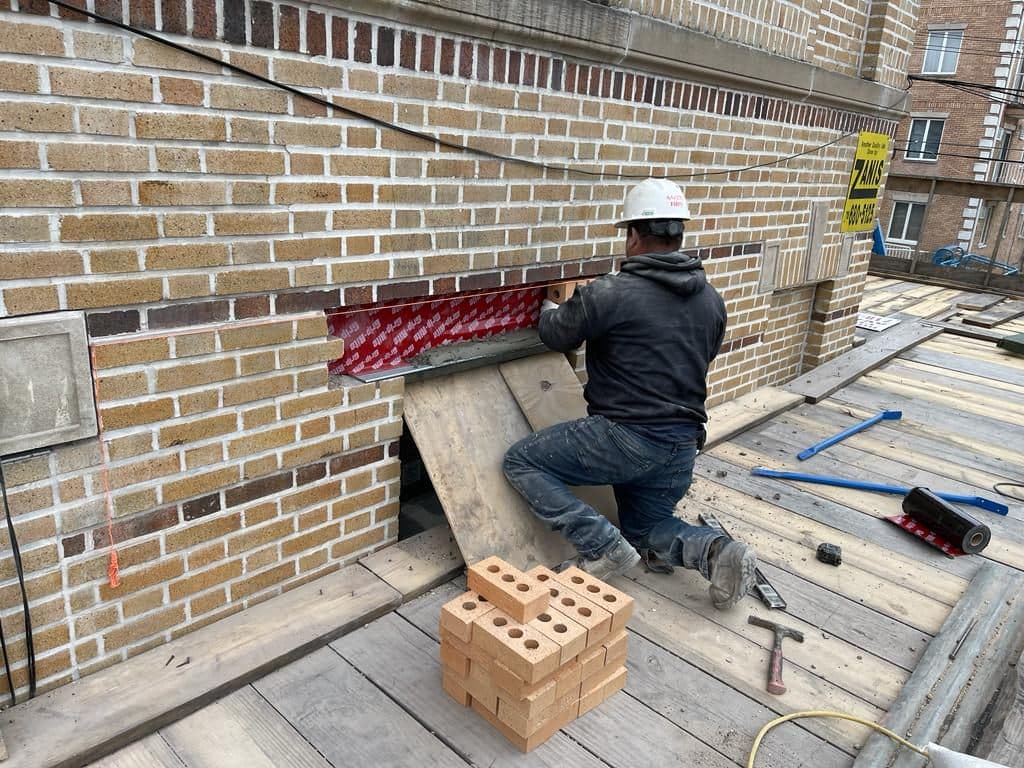 New primed steel lintel being set over a window