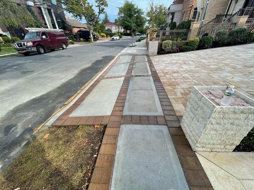 New sidewalk with brick-pattern strips at the street