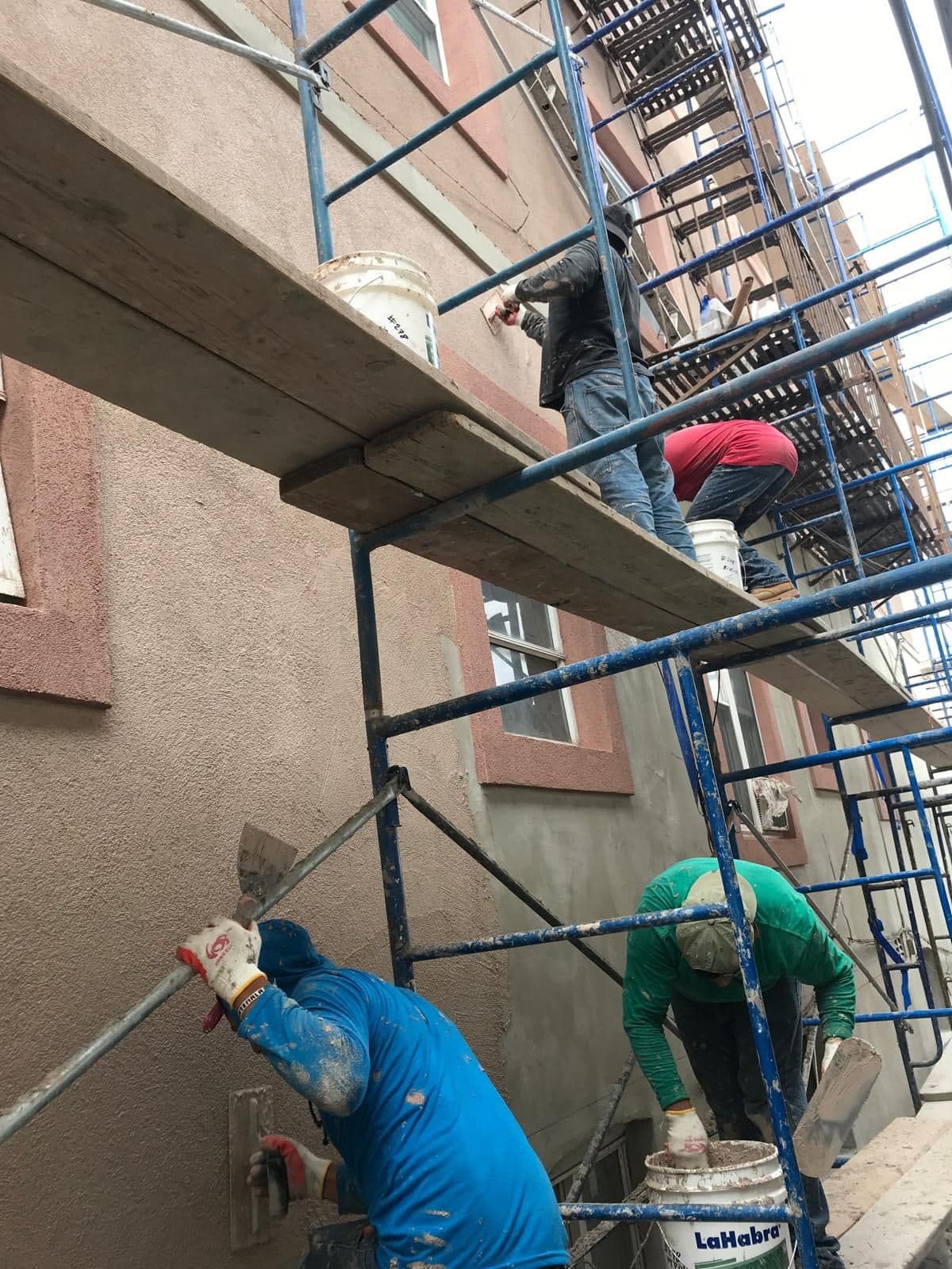 Crew applying the finish coat from the scaffold