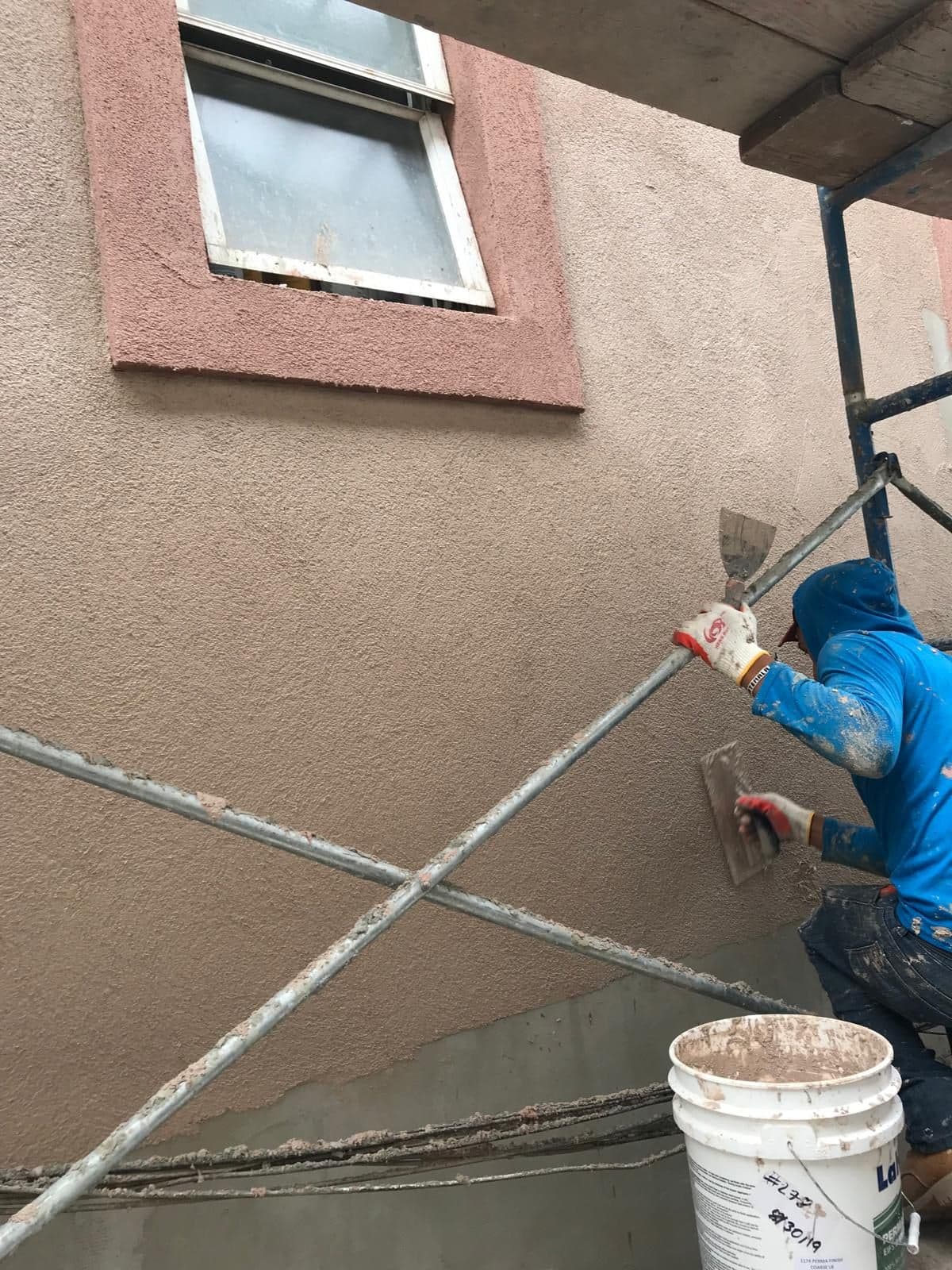 Plasterer finishing the stucco around a window