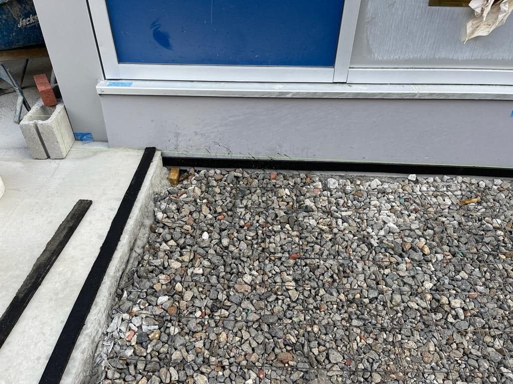 Gravel base with joint filler along the building line