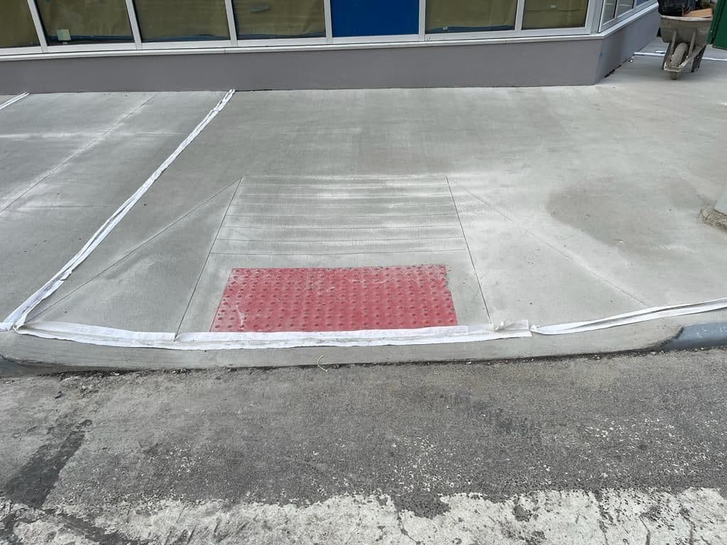 Finished corner ramp with a red detectable warning pad