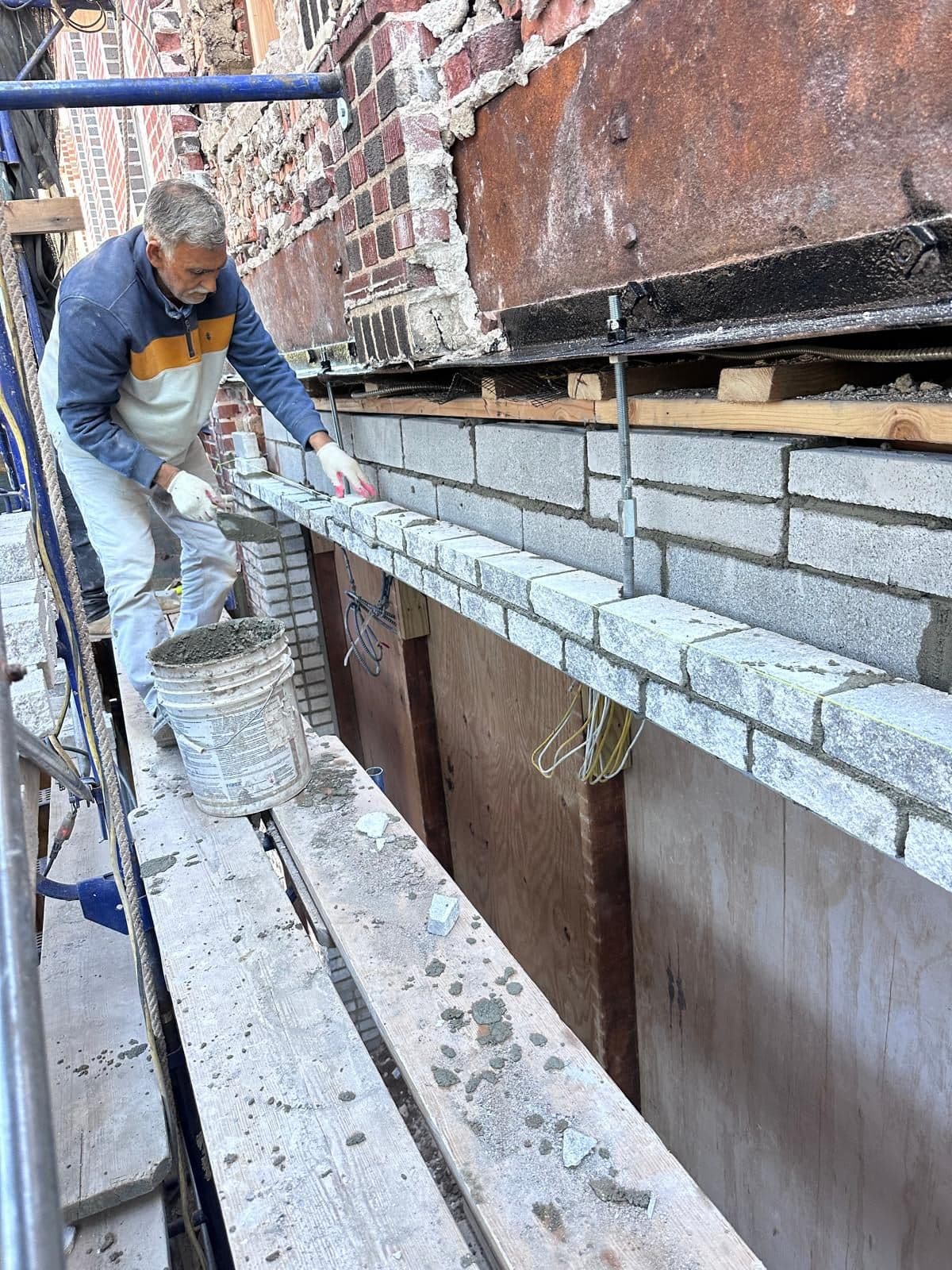 Crew laying new brick on a Brooklyn facade