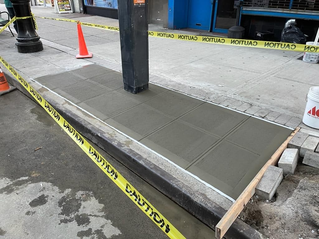 Fresh concrete in the replaced sidewalk flags