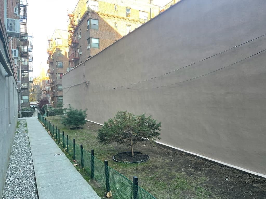 After: the same wall finished in smooth tan cement stucco