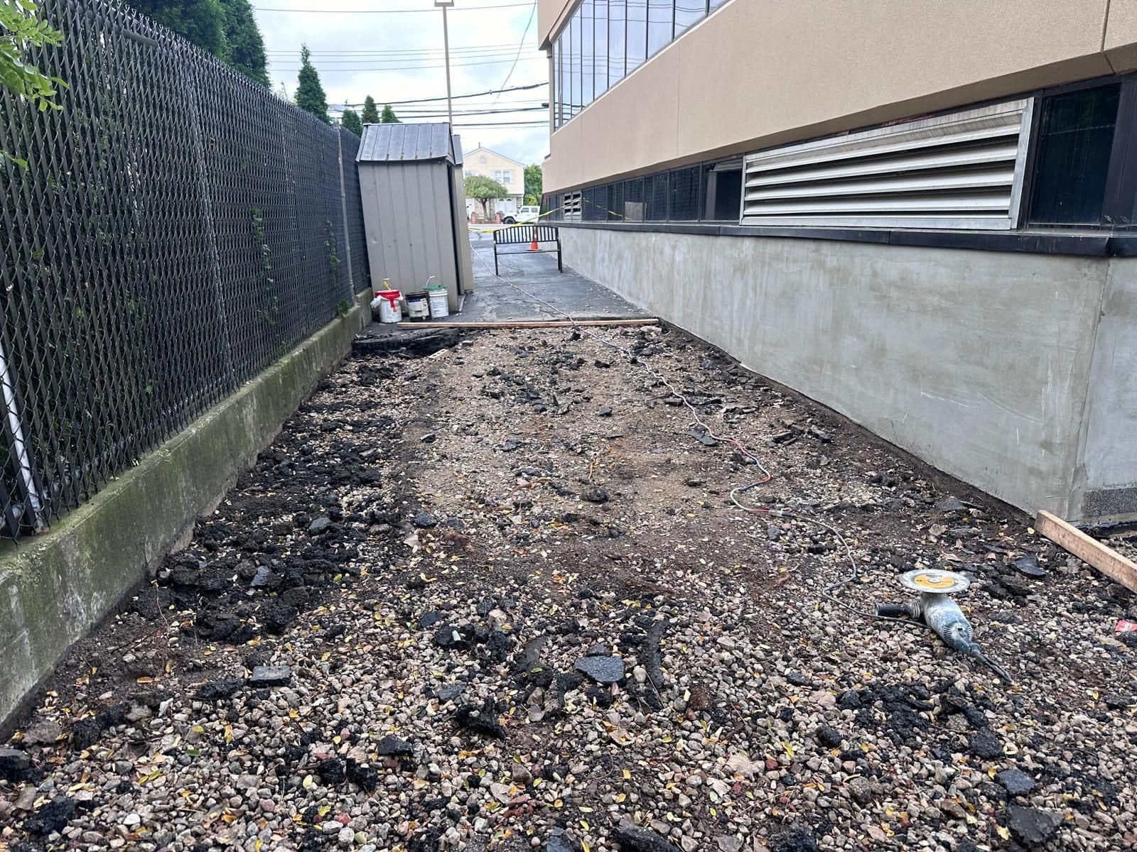 Before: dirt and rubble along the side of a commercial building