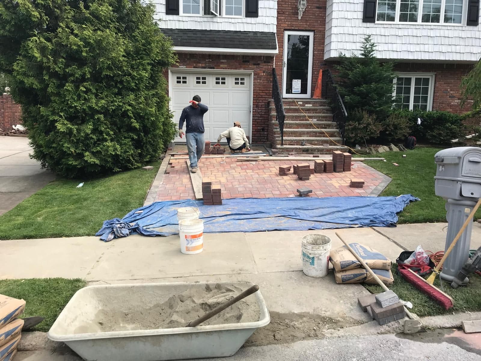 Crew laying the first pavers at the garage