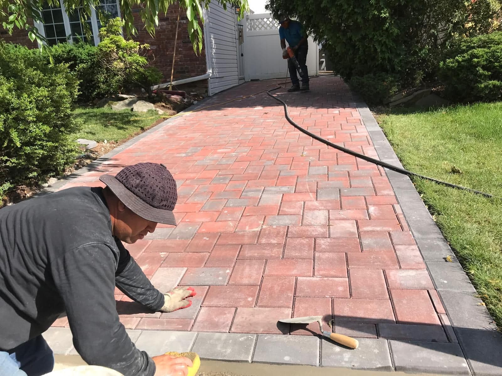 Worker setting the edge pavers along the side walkway