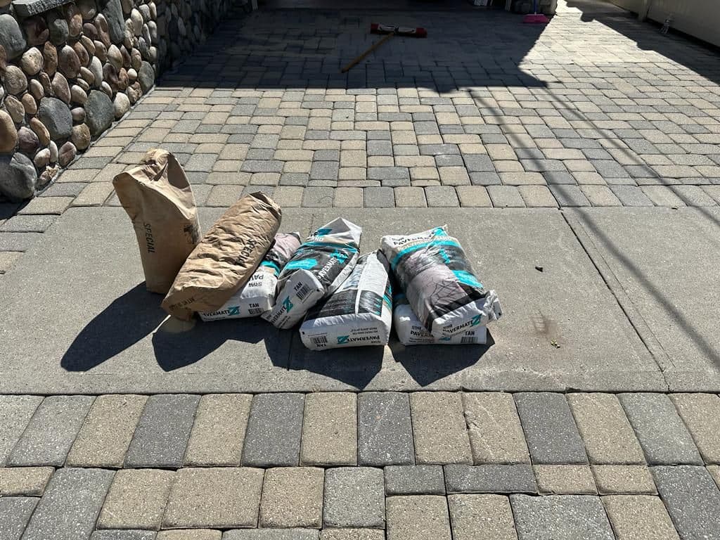 Bags of joint sand ready on the driveway