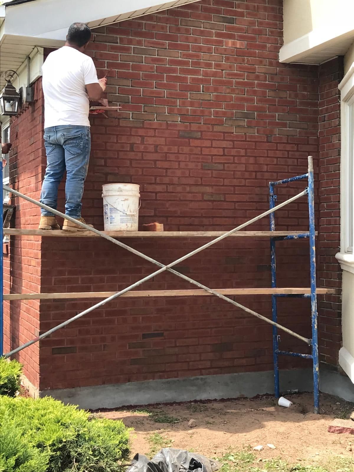 Mason pointing brick from a scaffold