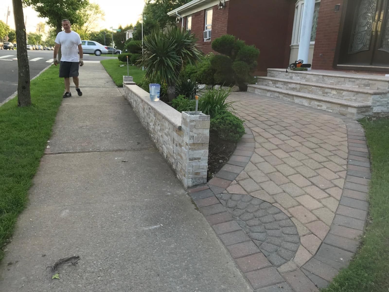 New stone-capped garden wall beside a paver walkway
