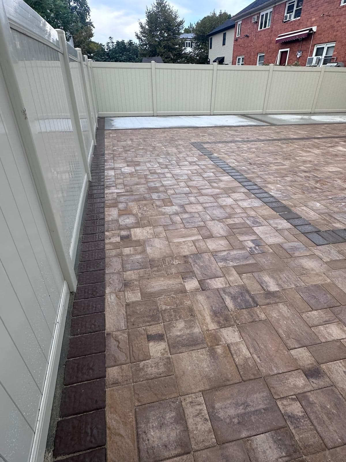 Finished backyard pavers with a darker border